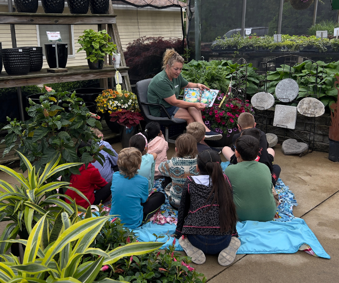Wasson staff member reading a book to a group of young students at Wasson in Union City
