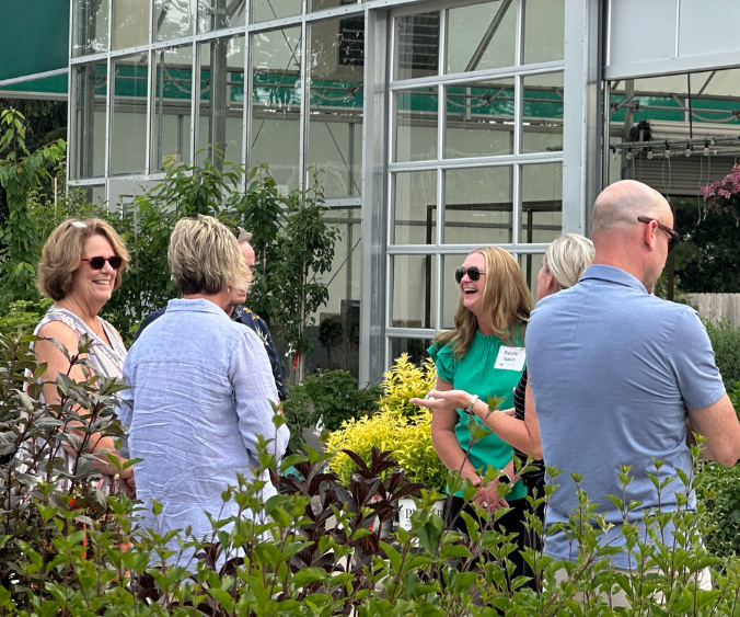 A photo of men and women enjoying conversation during an organization gathering hosted at Wasson's Fishers Garden Center