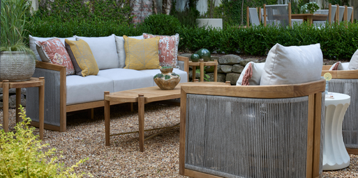 Display of outdoor living furniture including a sofa, two chairs, and a coffee table