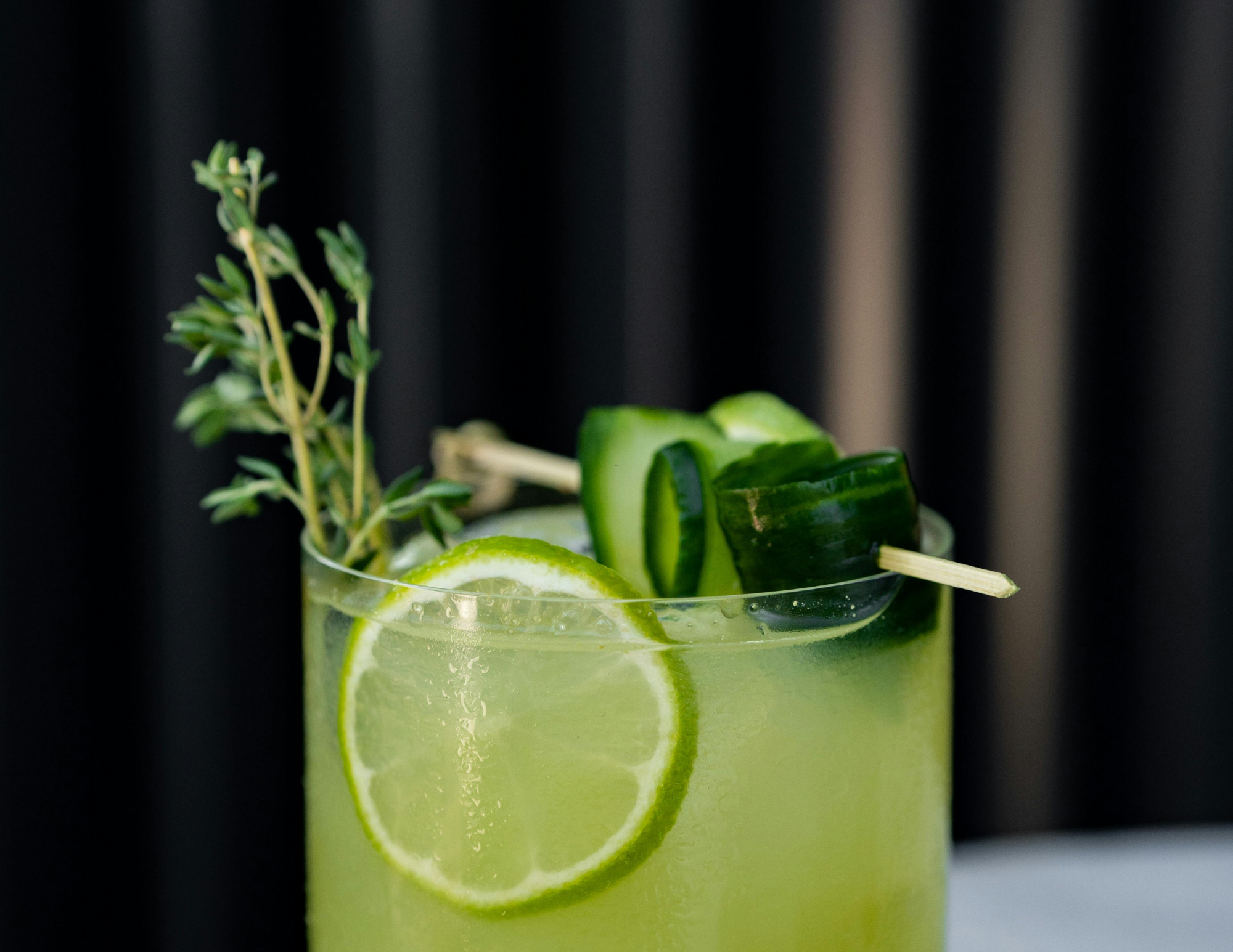 Green mocktail with herb and lime garnish